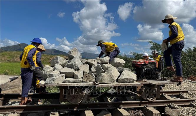 Công nhân thi công khắc phục sạt lở đường sắt. Ảnh: Tường Quân - TTXVN