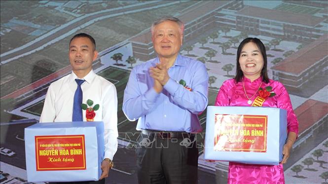 Đồng chí Nguyễn Hòa Bình, Ủy viên Bộ Chính trị, Phó Thủ tướng Thường trực Chính phủ tặng quà cho trường Tiểu học và Trung học cơ sở Sơn Kim 1. Ảnh: Hữu Quyết - TTXVN