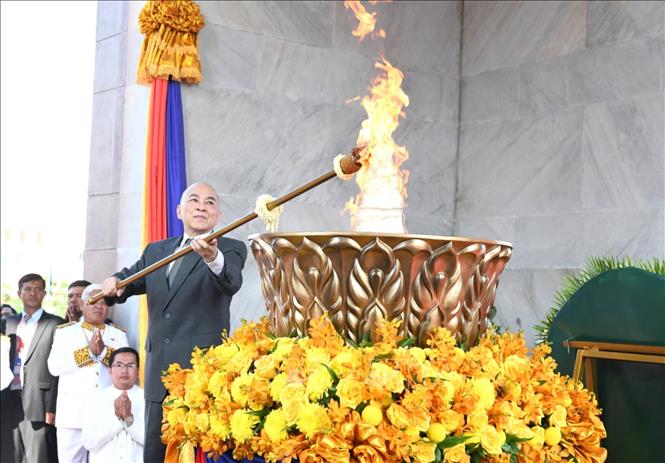Quốc vương Campuchia Norodom Sihamoni thực hiện nghi thức thắp đuốc tại Đài Độc lập ở thủ đô Phnom Penh sáng ngày 9/11/2025. Theo chương trình lễ quốc khánh, ngọn lửa sẽ cháy trong 3 ngày, tượng trưng cho niềm tự hào, nền độc lập và sự thống nhất. Ảnh: AKP/TTXVN phát