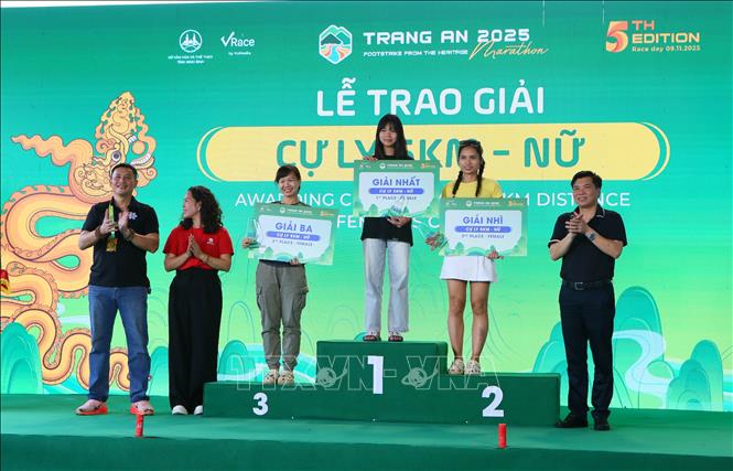 Ban tổ chức trao giải cho các vận động viên đoạt giải tại nội dung nữ, cự ly 5km. Ảnh: Công Luật - TTXVN