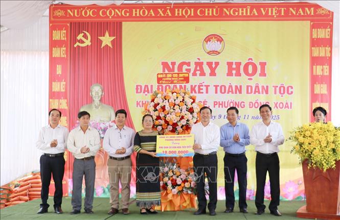 Lãnh đạo phường Đồng Xoài tặng hoa chúc mừng và quà cho cán bộ, nhân dân khu phố Bưng Sê. Ảnh: Nhật Bình - TTXVN.