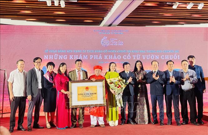 Giám đốc Sở Văn hóa và Thể thao Hà Nội Bạch Liên Hương trao Bằng xếp hạng Di tích cấp tỉnh, thành phố Di chỉ khảo cổ Vườn Chuối và tặng hoa chúc mừng Đảng bộ, chính quyền và nhân dân phường Hoài Đức. Ảnh: Tuyết Mai - TTXVN