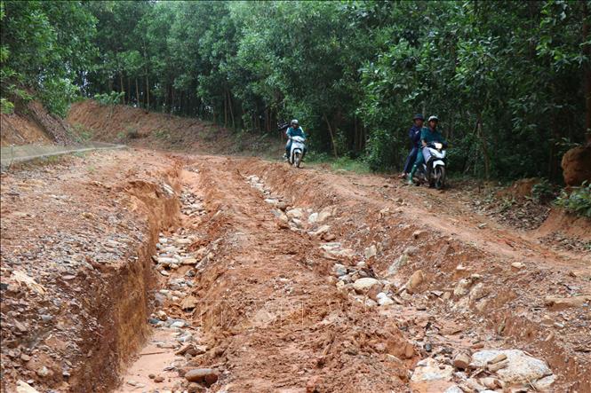 Nước lũ khiến mặt đường Sơn Tinh - Sơn Thượng, xã Sơn Tây Hạ lầy lội, trơn trượt, tạo thành các rãnh sâu khiến người dân gặp nhiều khó khăn. Ảnh: Phạm Cường - TTXVN 