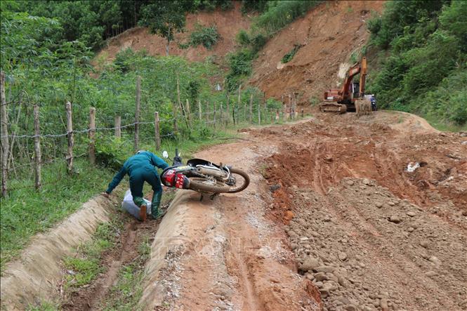 Nhiều người té ngã khi lưu thông qua 3,5km đường Sơn Tinh - Sơn Thượng, xã Sơn Tây Hạ lầy lội, trơn trượt do mưa lũ. Ảnh: Phạm Cường-TTXVN