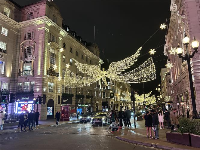 Du khách thích thú dạo phố, mua sắm và chụp ảnh với đèn trang trí tại đại lộ Shaftesbury Avenue. Ảnh: Phong Hà-PV TTXVN tại Anh