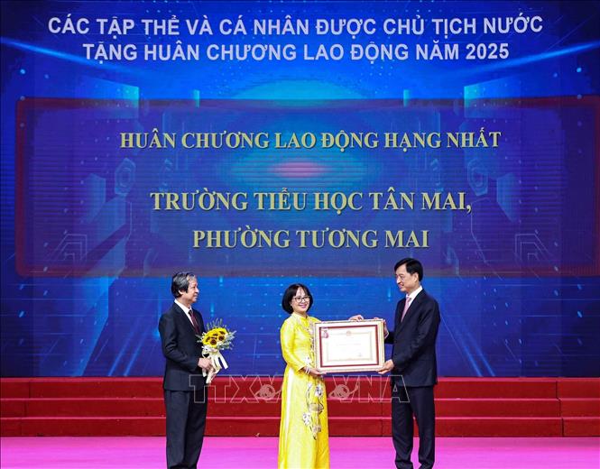 Bí thư Thành ủy Hà Nội Nguyễn Duy Ngọc cùng Bộ trưởng Bộ Giáo dục và Đào tạo Nguyễn Kim Sơn trao Huân chương Lao động hạng Nhất của Chủ tịch nước tặng Trường Tiểu học Tân Mai, phường Tương Mai. Ảnh: Thanh Tùng - TTXVN 