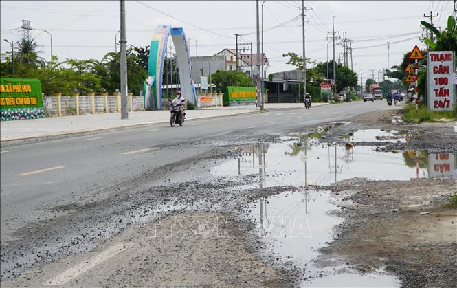 Quốc lộ 80, đoạn qua xã Phú Hựu, tỉnh Đồng Tháp, xuất hiện “ổ gà”, đọng nước, nguy cơ gây mất an toàn giao thông, nhất là vào đêm tối. Ảnh: Nhựt An - TTXVN
