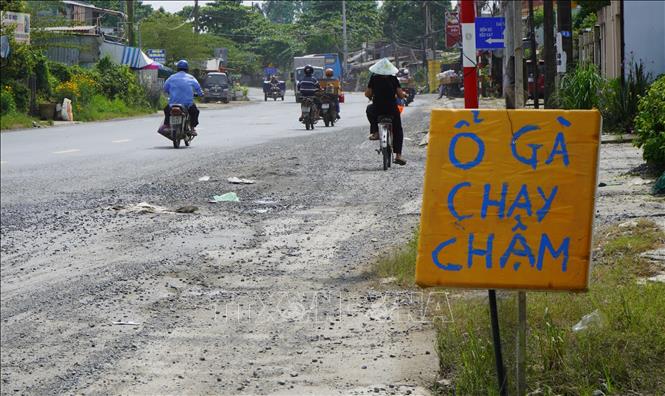 Người dân đặt biển cảnh báo “ổ gà” trên Quốc lộ 80, đoạn qua xã Tân Nhuận Đông, tỉnh Đồng Tháp. Ảnh: Nhựt An - TTXVN