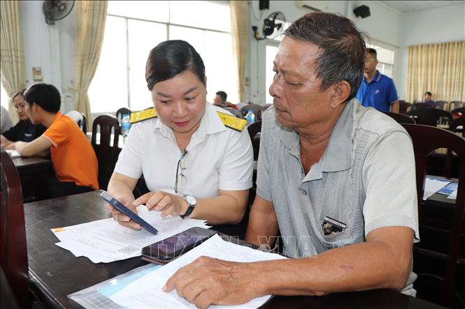 Nhiều hộ kinh doanh lớn tuổi, không am hiểu về công nghệ nên gặp khó khăn khi thao tác các ứng dụng điện tử kê khai thuế. Ảnh: Thu Hiền - TTXVN