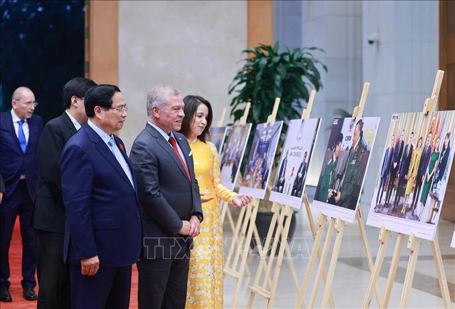 Thủ tướng Phạm Minh Chính và Quốc vương Jordan Abdullah II Ibn Al Hussein tham quan trưng bày ảnh về quan hệ hợp tác giữa hai nước, do Thông tấn xã Việt Nam thực hiện. Ảnh: Dương Giang-TTXVN 
