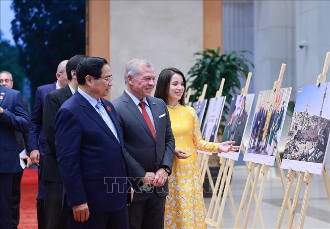 Thủ tướng Phạm Minh Chính và Quốc vương Jordan Abdullah II Ibn Al Hussein tham quan trưng bày ảnh về quan hệ hợp tác giữa hai nước, do Thông tấn xã Việt Nam thực hiện. Ảnh: Dương Giang-TTXVN 
