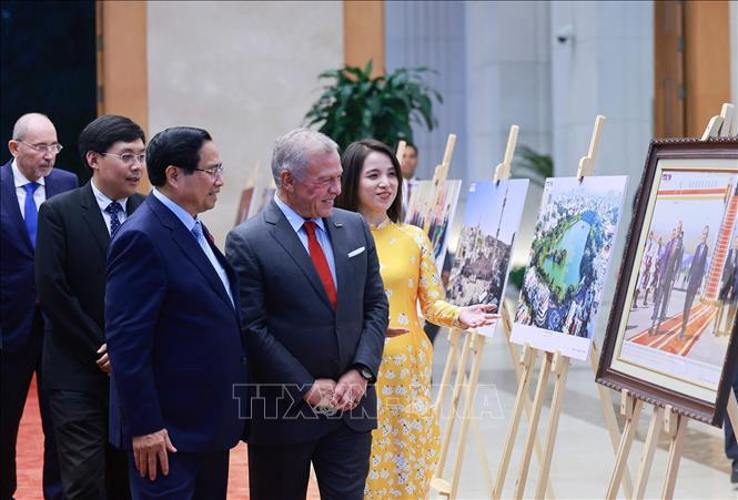 Thủ tướng Phạm Minh Chính và Quốc vương Jordan Abdullah II Ibn Al Hussein tham quan trưng bày ảnh về quan hệ hợp tác giữa hai nước, do Thông tấn xã Việt Nam thực hiện. Ảnh: Dương Giang-TTXVN 

