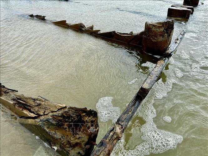 Phần khung gỗ con tàu nổi trên mặt cát. Ảnh: Trần Lê Lâm - TTXVN