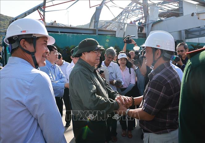 Thủ tướng Phạm Minh Chính kiểm tra các cơ sở sản xuất bị thiệt hại do bão số 13 tại Khu kinh tế Nhơn Hội. Ảnh: Dương Giang-TTXVN 
