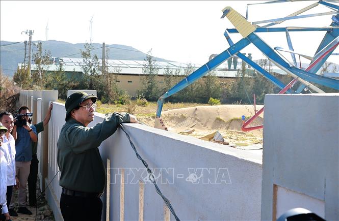 Thủ tướng Phạm Minh Chính kiểm tra các cơ sở sản xuất bị thiệt hại do bão số 13 tại Khu kinh tế Nhơn Hội. Ảnh: Dương Giang-TTXVN 
