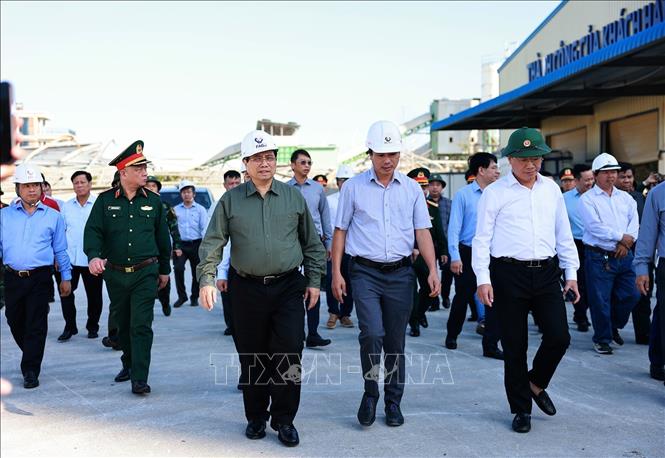 Thủ tướng Phạm Minh Chính thăm các cơ sở sản xuất bị thiệt hại do bão số 13 tại Khu kinh tế Nhơn Hội. Ảnh: Dương Giang-TTXVN 
