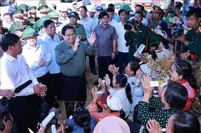 Thủ tướng Phạm Minh Chính thăm hỏi, động viên các hộ dân bị ảnh hưởng bởi triều cường tại xã Đề Gi. Ảnh: Dương Giang-TTXVN 
