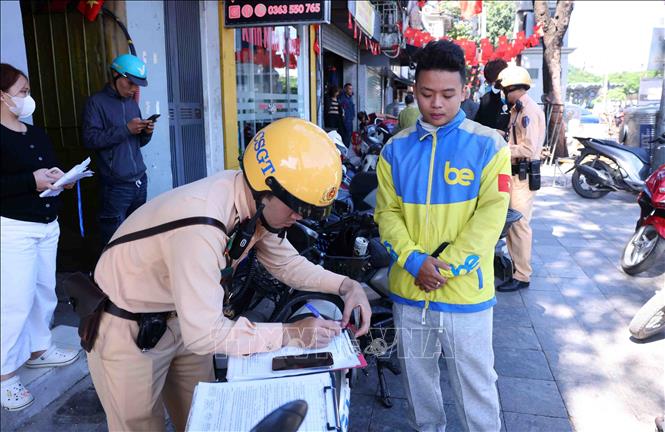 Một tài xế công nghệ cố tình dán, che biển số xe đã bị tổ công tác thuộc đội CSGT số 1 phát hiện và lập biên bản xử lý theo quy định của pháp luật. Ảnh: Phạm Kiên - TTXVN