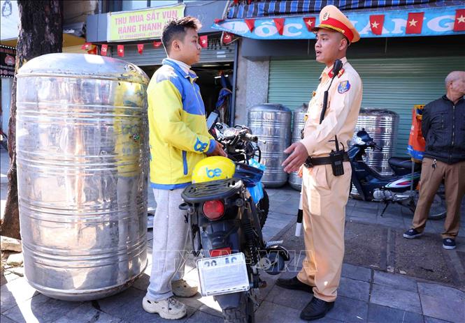 Những trường hợp vi phạm lỗi dán, che biển kiểm soát chủ yếu là tài xế xe ôm công nghệ và người giao hàng để đối phó với lực lượng chức năng. Ảnh: Phạm Kiên - TTXVN