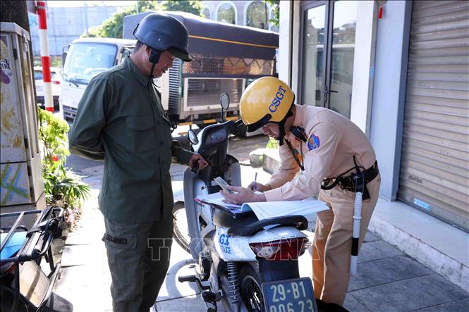 Một trường hợp dán, che biển số xe đã bị tổ công tác thuộc đội CSGT số 1 phát hiện và lập biên bản xử lý theo quy định của pháp luật. Ảnh: Phạm Kiên - TTXVN