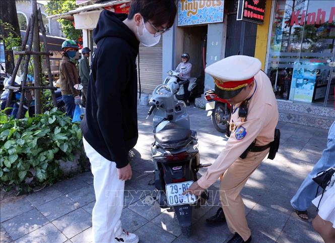 Các trường hợp dán, che biển số khi tham gia giao thông được yêu cầu khôi phục tình trạng ban đầu. Ảnh: Phạm Kiên - TTXVN