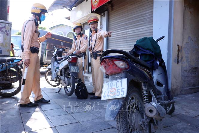 Theo Nghị định 168/2024/NĐ-CP, hành vi “Điều khiển xe gắn biển số không đúng quy cách; gắn biển số không rõ chữ, số hoặc sử dụng chất liệu khác sơn, dán lên chữ, số của biển số xe; gắn biển số bị bẻ cong, che lấp, làm thay đổi màu sắc, hình dạng, kích thước” sẽ bị phạt tiền từ 4–6 triệu đồng và trừ 6 điểm giấy phép lái xe. Ảnh: Phạm Kiên - TTXVN