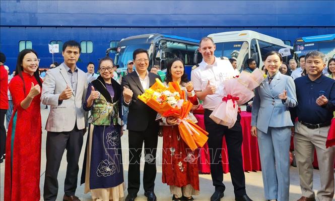 Lãnh đạo Sở Văn hóa, Thể thao và Du lịch tỉnh Quảng Ninh tặng hoa chào mừng đoàn khách. Ảnh: Văn Đức - TTXVN