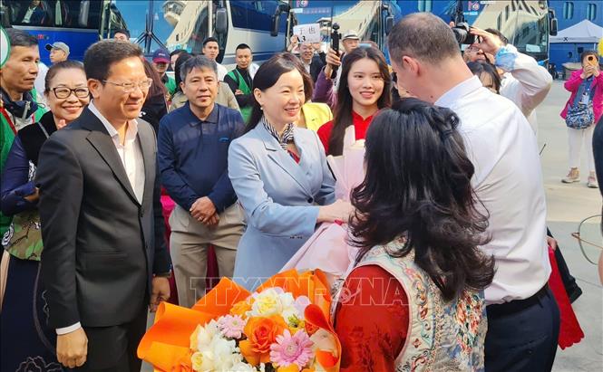 Lãnh đạo Sở Văn hóa, Thể thao và Du lịch tỉnh Quảng Ninh tặng hoa chào mừng đoàn khách. Ảnh: Văn Đức - TTXVN