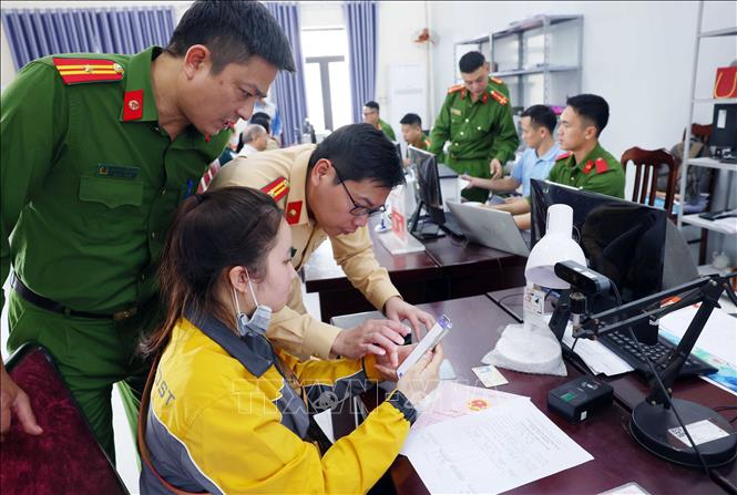 Cán bộ phòng CSGT phối hợp với lực lượng Công an xã Mê Linh hướng dẫn người dân làm sạch dữ liệu đăng ký phương tiện, giấy phép lái xe. Ảnh: Phạm Kiên - TTXVN