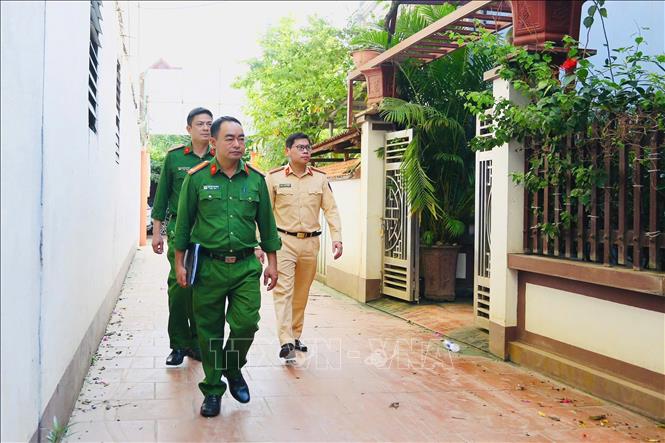 Cán bộ CSGT Hà Nội cùng với Công an xã Mê Linh xuống từng hộ dân tuyên truyền, hướng dẫn làm sạch dữ liệu đăng ký phương tiện, giấy phép lái xe. Ảnh: Phạm Kiên - TTXVN