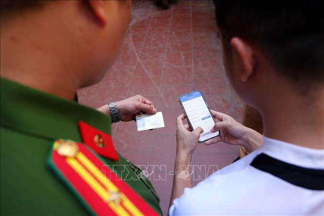 Công an xã Mê Linh hướng dẫn người dân làm sạch dữ liệu. Ảnh: Phạm Kiên - TTXVN