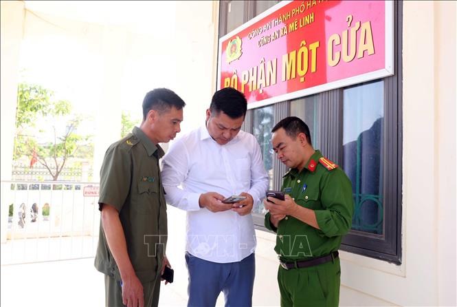 Công an xã Mê Linh hướng dẫn công dân trên địa bàn thực hiện làm sạch dữ liệu đăng ký phương tiện, giấy phép lái xe. Ảnh: Phạm Kiên - TTXVN
