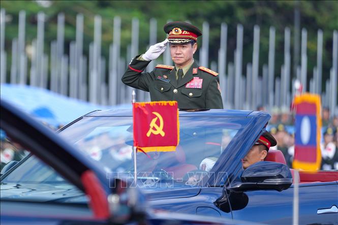 Thượng tướng Khamliang Outhakaysone, Bộ trưởng Bộ Quốc phòng Lào, thực hiện nghi thức điều lệnh tại lễ tổng hợp luyện. Ảnh: Đỗ Bá Thành - PV TTXVN tại Lào