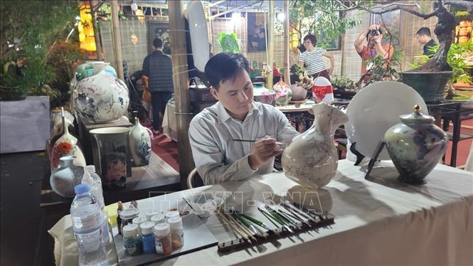 Nghệ nhân gốm sứ giới thiệu sản phẩm tại Festival. Ảnh: Phương Anh-TTXVN