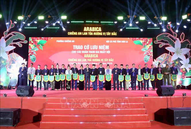 Trao cờ lưu niệm cho cá nhân, đơn vị, các bản, hợp tác xã và doanh nghiệp tham gia Ngày hội. Ảnh: Quang Quyết - TTXVN