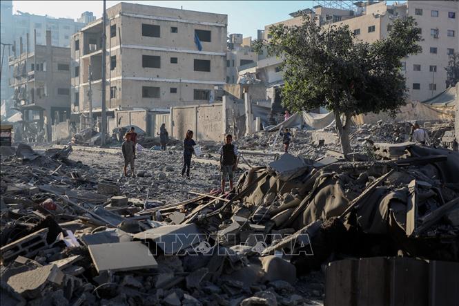Ngày 13/11/2025, Mỹ đã lưu hành một dự thảo nghị quyết sửa đổi của Hội đồng Bảo an LHQ, trong đó cho phép thành lập một chính quyền chuyển tiếp tại Dải Gaza có nhiệm kỳ 2 năm và một lực lượng quốc tế để giám sát an ninh cũng như đảm bảo vấn đề phi quân sự hóa tại dải đất ven Địa Trung Hải này. Nga cũng đang lưu hành một dự thảo nghị quyết riêng, được truyền cảm hứng từ đề xuất của Mỹ nhưng có thêm cách tiếp cận “cân bằng và thống nhất” nhằm hướng đến ngừng bắn bền vững tại Gaza. Ảnh: Toà nhà bị phá huỷ trong xung đột tại phía Tây thành phố Gaza. Ảnh: THX/TTXVN