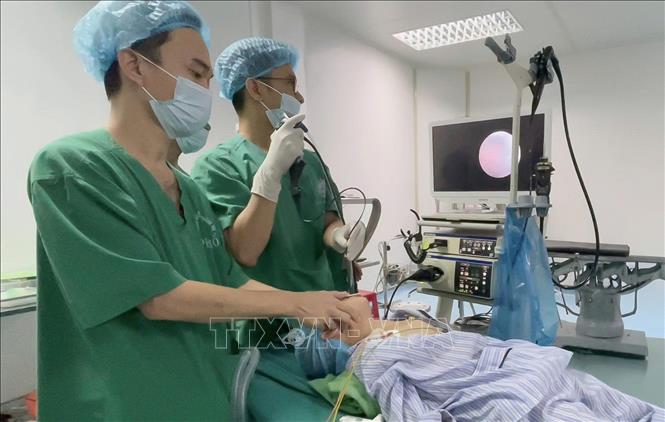 Các bác sỹ thực hiện phẫu thuật nội soi phế quản cấp cứu để lấy chiếc kim chọc tuỷ trong đường thở của bé trai. Ảnh: TTXVN phát