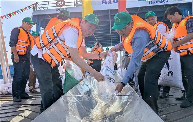 Ông Ngô Công Thức, Phó Chủ tịch UBND tỉnh An Giang và Phó Cục trưởng Cục Thủy sản và Kiểm ngư - Bộ Nông nghiệp và Môi trường Nguyễn Quang Hùng cùng nhau thả cá giống xuống sông Hậu, qua đó góp phần phục hồi, tái tạo nguồn lợi thủy sản cho ngày nay và thế hệ mai sau. Ảnh: Công Mạo-TTXVN