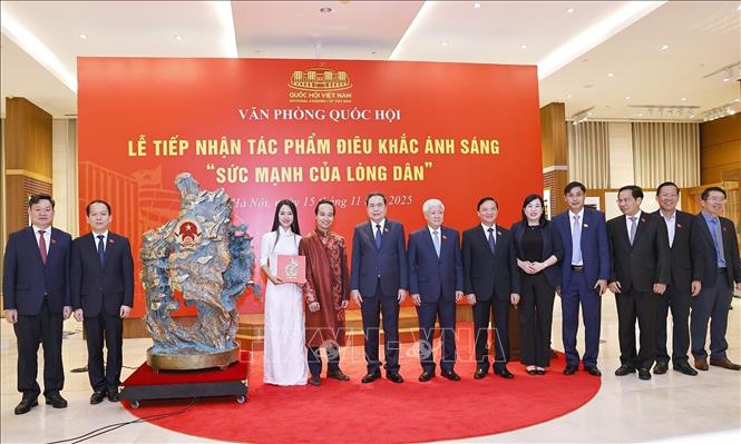  Chủ tịch Quốc hội Trần Thanh Mẫn và đại biểu với nghệ nhân tại Lễ tiếp nhận tác phẩm điêu khắc ánh sáng. Ảnh: Doãn Tấn - TTXVN
