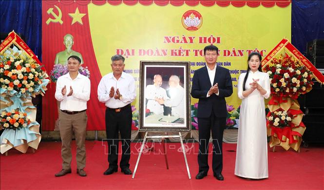 Chủ tịch UBND tỉnh Ninh Bình Trần Huy Tuấn tặng tổ dân phố Thanh Nộn 2 bức tranh “Bác Hồ và Bác Tôn bắt tay kết đoàn”. Ảnh: Nguyễn Chinh - TTXVN