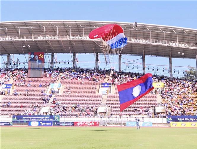 Màn nhảy dù từ độ cao 2.000m xuống sân vận động quốc gia ở thủ đô Viêng Chăn (Lào) của 1 chiến sĩ mang theo cờ Tổ quốc Lào tại lễ khai mạc. Ảnh: Đỗ Bá Thành - PV TTXVN tại Lào