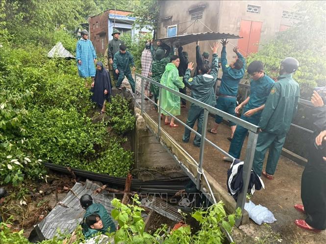 Cán bộ, chiến sĩ Đồn biên phòng cửa khẩu cảng Nha Trang phối hợp cùng các lực lượng địa phương tổ chức khơi thông các kênh, rãnh thoát nước không để tắc nghẽn. Ảnh: TTXVN phát