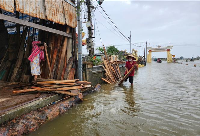Người dân phường Kim Trà, thành phố Huế di chuyển vật dụng lên chỗ cao để tránh ngập lụt khi lũ trên sông Bồ lên cao sáng 17/11. Ảnh: Nguyên Lý-TTXVN
