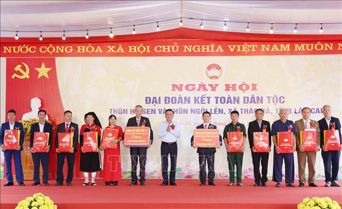Thường trực Ban Bí thư Trần Cẩm Tú tặng quà cho các gia đình tiêu biểu tại thôn Hồ Sen và thôn Ngòi Lẻn, xã Thác Bà. Ảnh: Phương Hoa - TTXVN