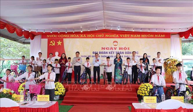 Thường trực Ban Bí thư Trần Cẩm Tú tặng quà cho thiếu nhi có hoàn cảnh khó khăn tại thôn Hồ Sen và thôn Ngòi Lẻn, xã Thác Bà. Ảnh: Phương Hoa - TTXVN