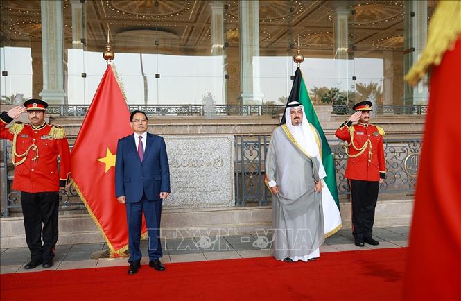 Thủ tướng Phạm Minh Chính và Thủ tướng Kuwait Sheikh Ahmad Abdullah Al-Ahmad Al Sabah nghe quân nhạc cử Quốc thiều hai nước. Ảnh: Dương Giang-TTXVN