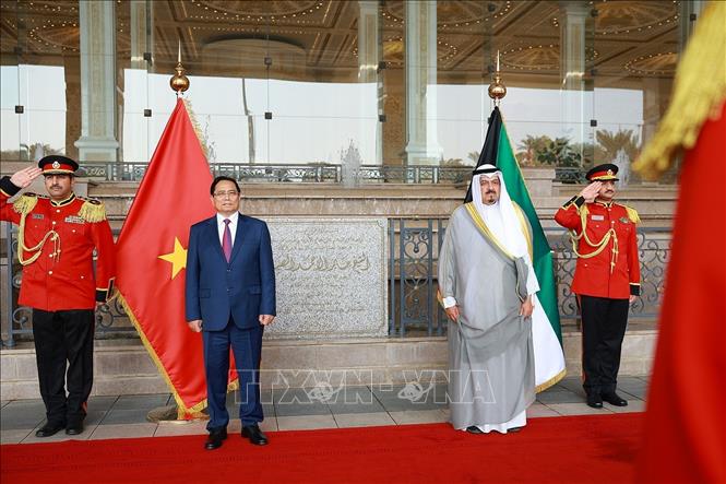 Thủ tướng Phạm Minh Chính và Thủ tướng Kuwait Sheikh Ahmad Abdullah Al-Ahmad Al Sabah nghe quân nhạc cử Quốc thiều hai nước. Ảnh: Dương Giang-TTXVN