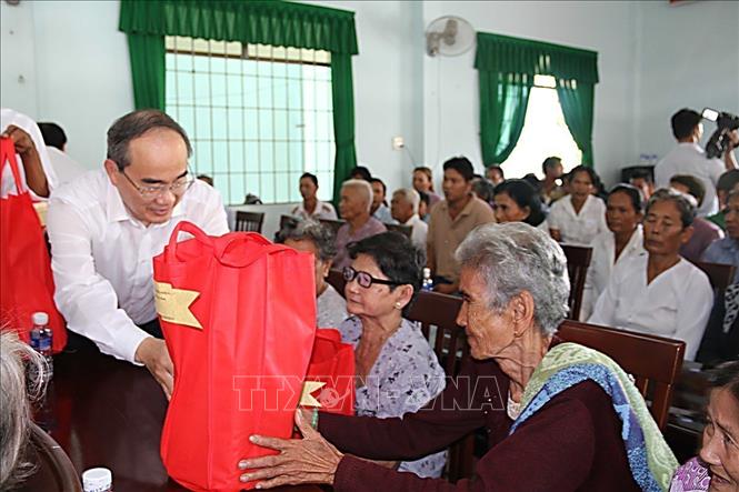 Bí thư Thành ủy thành phố Hồ Chí Minh Nguyễn Thiện Nhân tặng quà cho nhân dân tại Ngày hội Đại đoàn kết toàn dân tộc tại ấp Kim Câu, xã Kim Hòa, huyện Cầu Ngang, tỉnh Trà Vinh (2018). Ảnh: Phúc Sơn – TTXVN