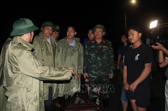 Các lực lượng chức năng động viên, thăm hỏi người dân xã Diên Điền ở khu vực bị ngập lụt, tối 17/11. Ảnh: Phan Sáu - TTXVN