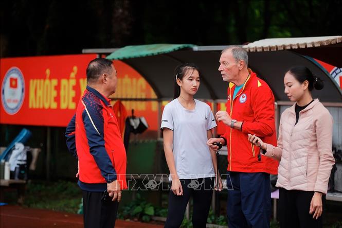 Chuyên gia chia sẻ cùng huấn luyện viên và VĐV tuyển điền kinh Việt Nam. Ảnh: Minh Quyết – TTXVN

